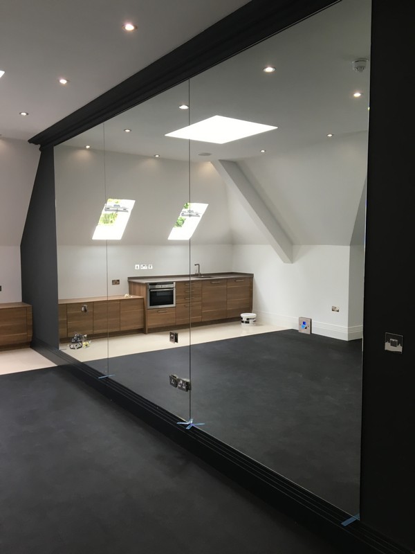 Frameless glass partition in loft conversion by Camden Town glaziers